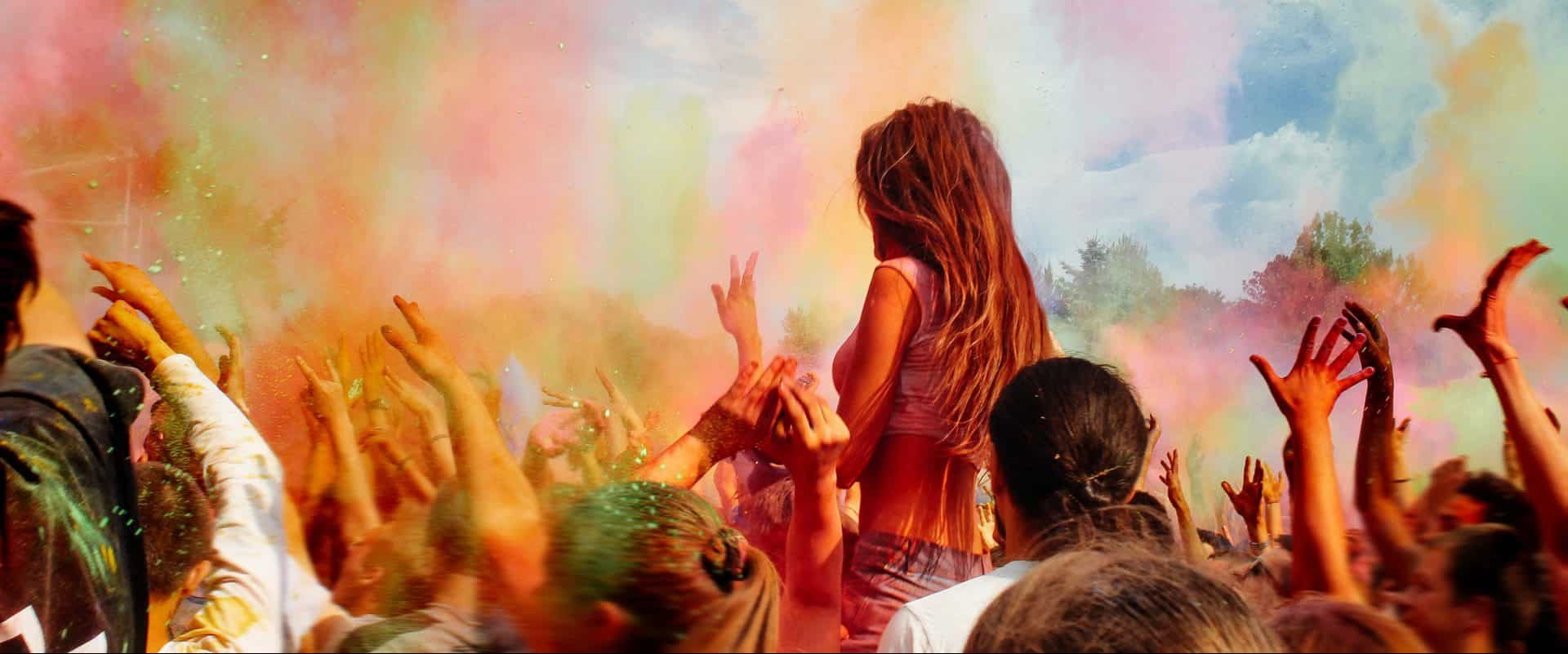 Happy People Crowd Partying Under Colorful Powder Cloud At Holi